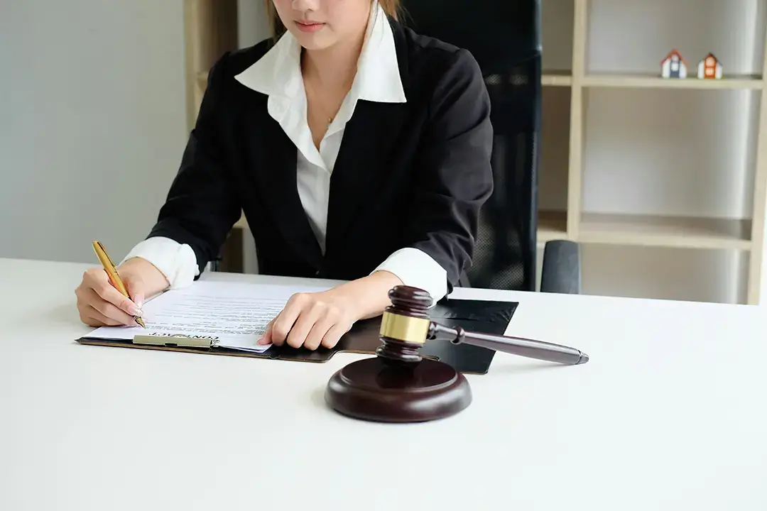 Lawyer writing at desk with gavel.