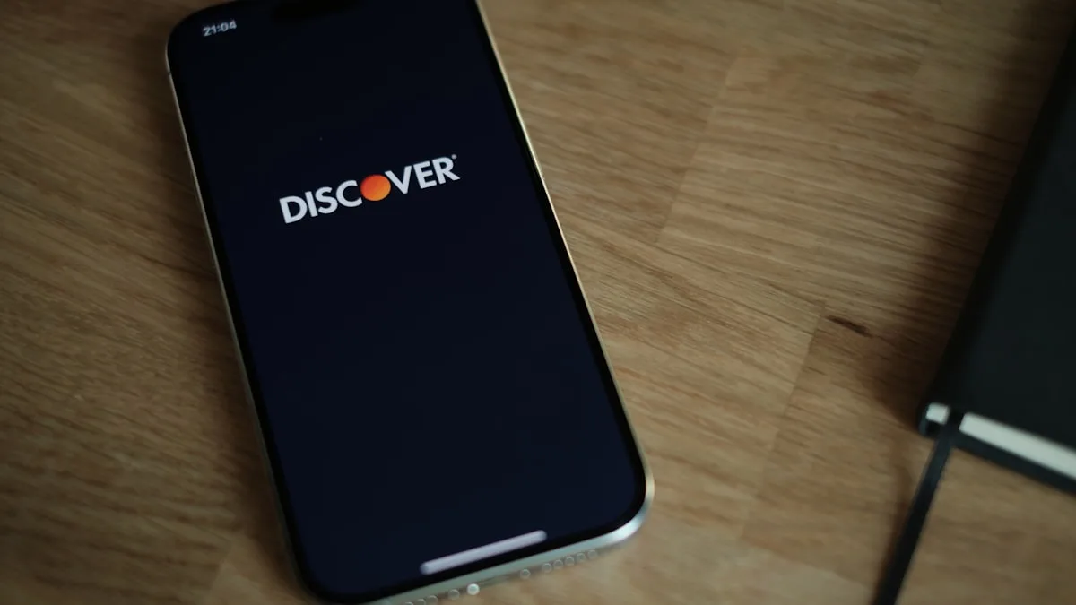 Smartphone displaying Discover logo on wooden table.