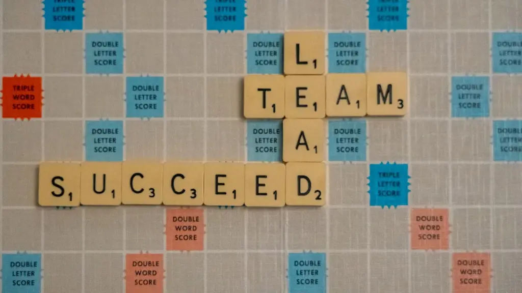 Scrabble board showing words team, lead and succeed