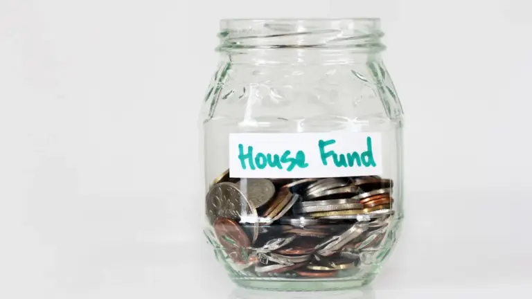 Glass jar labelled House Fund filled with coins